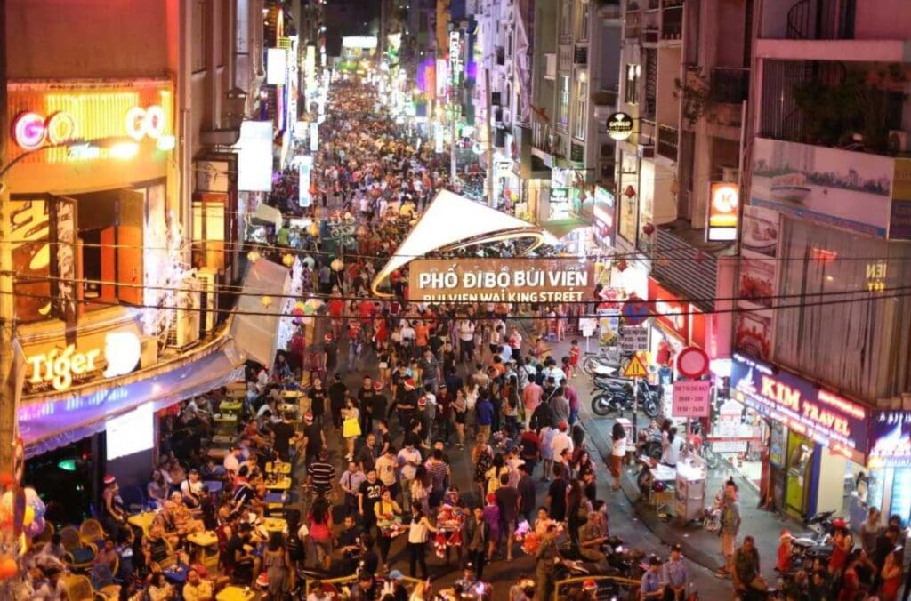 Crowds enjoying the vibrant nightlife at Bui Vien Walking Street in Ho Chi Minh City, filled with bars, restaurants, and colorful lights.