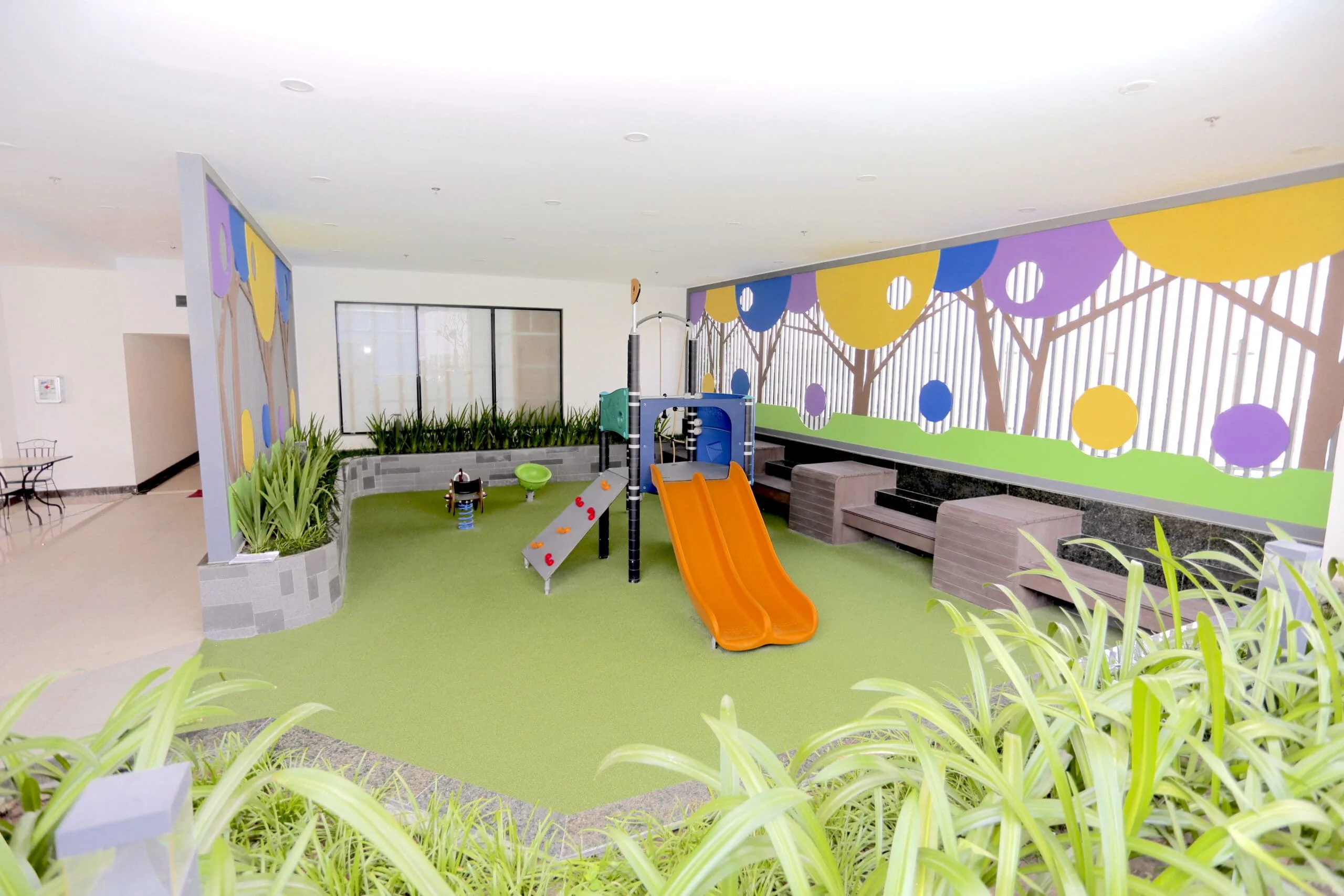 Children's indoor play area with slides and vibrant colors at RiverGate Residence